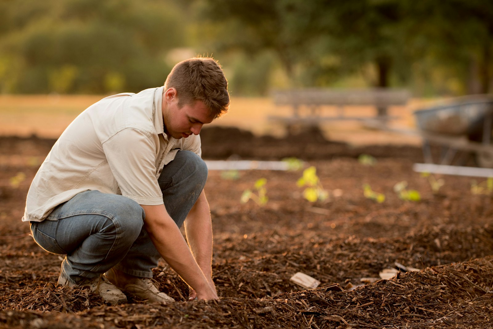 Gardener working compost or soil into a home garden bed